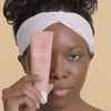 African American model warming Pumpkin Pore Detox Mask & Scrub on her hands and applying the detoxifying mask to her face 