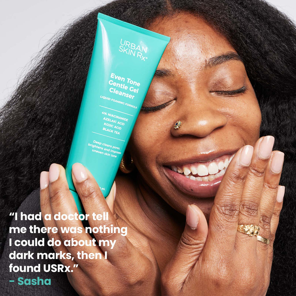 Woman holding bottle of Urban Skin RX Even Tone Gentle Gel Cleanser next to her face