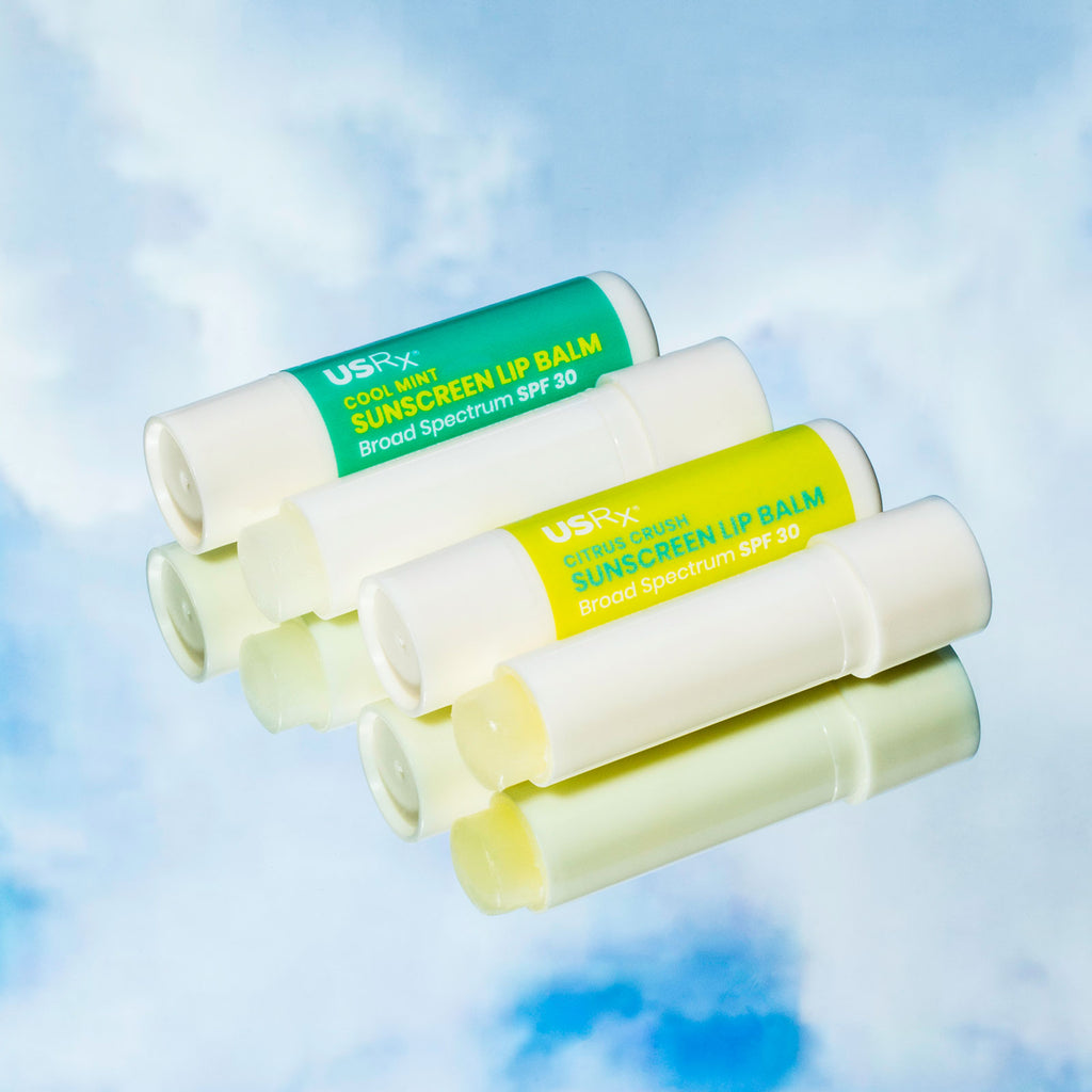 4 opened sticks of USRX Sunscreen Lip Balm SPF 30 set against a light blue sky background