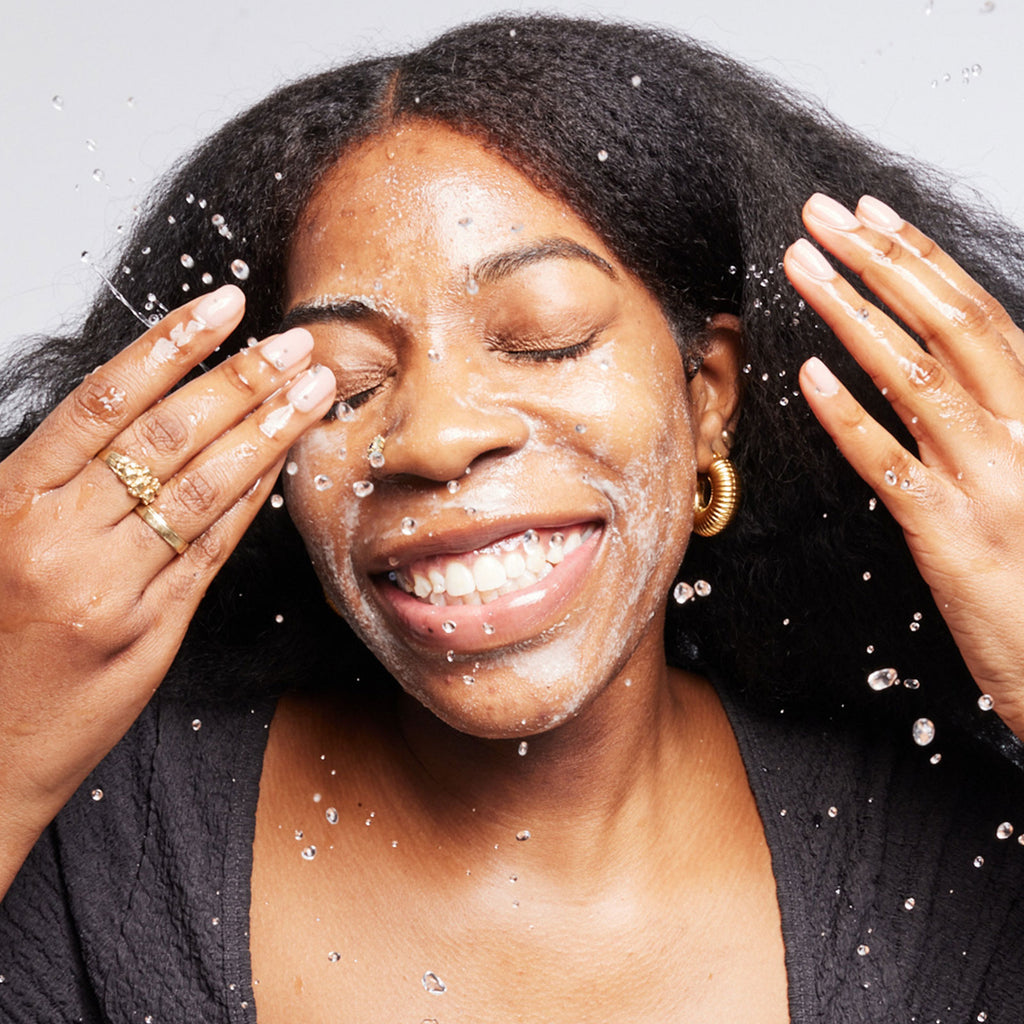 Woman with a happy expression with water droplets on her face.