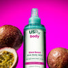 Bottle of USRX Glow Boost AHA Body Mist in Passionfruit Paloma next to tropical fruits