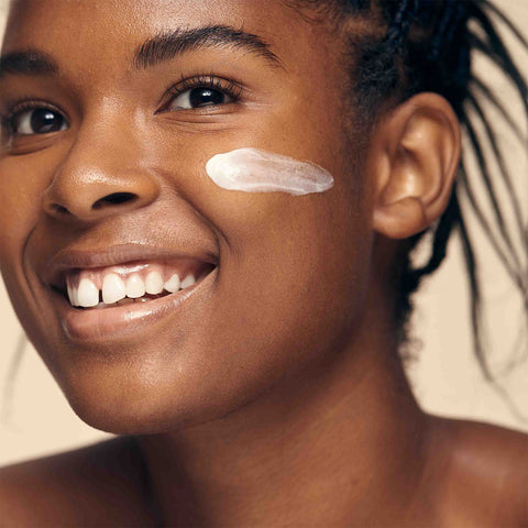 African American model with Radiant & Bright Glowing Moisturizer applied to her face which smooths the look of skin texture