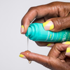 Woman dispensing Urban Skin RX YouthHero AM/PM Serum onto her finger
